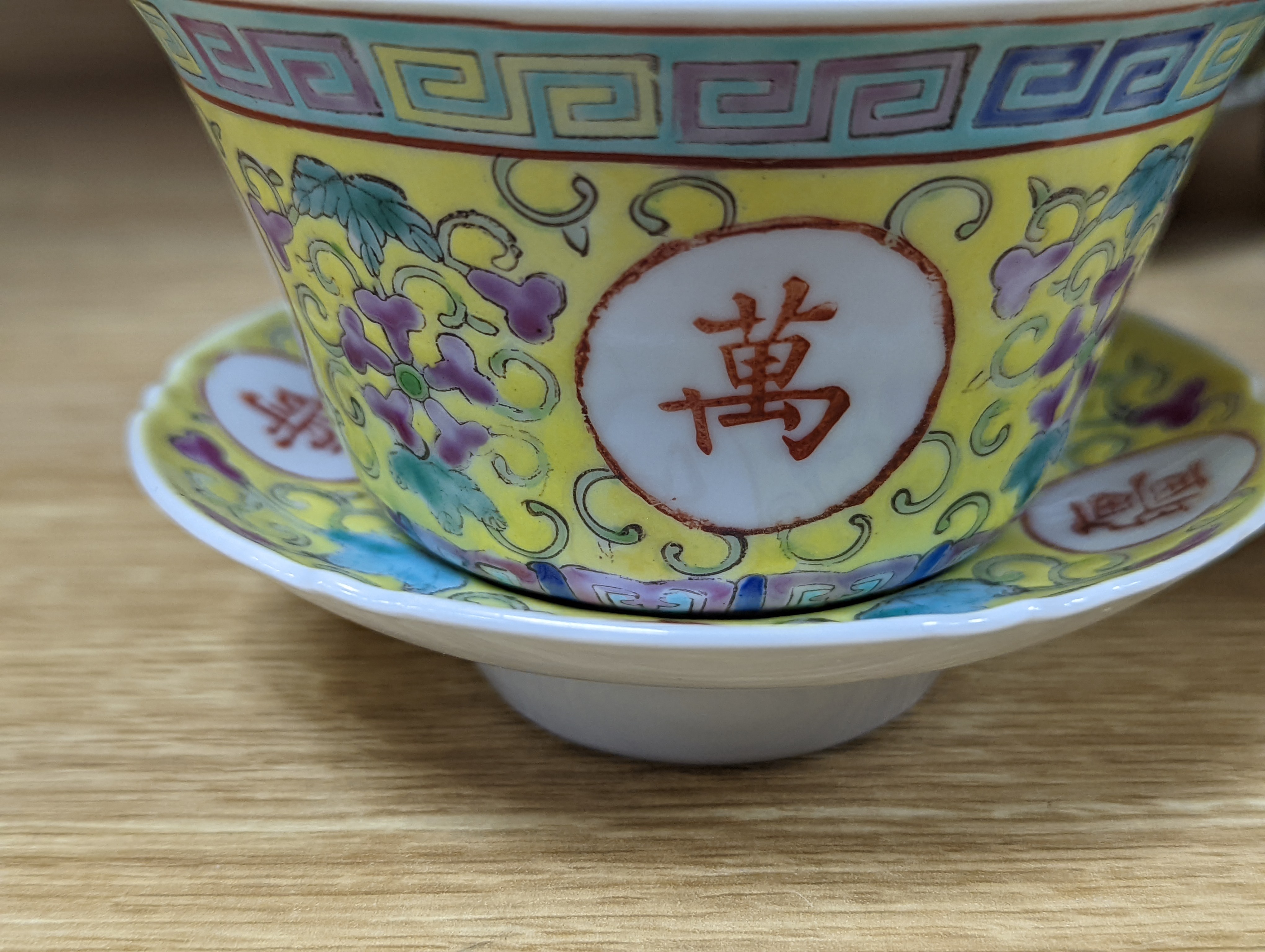 A pair of Chinese enamelled porcelain rice bowls, covers and stands and an odd bowl